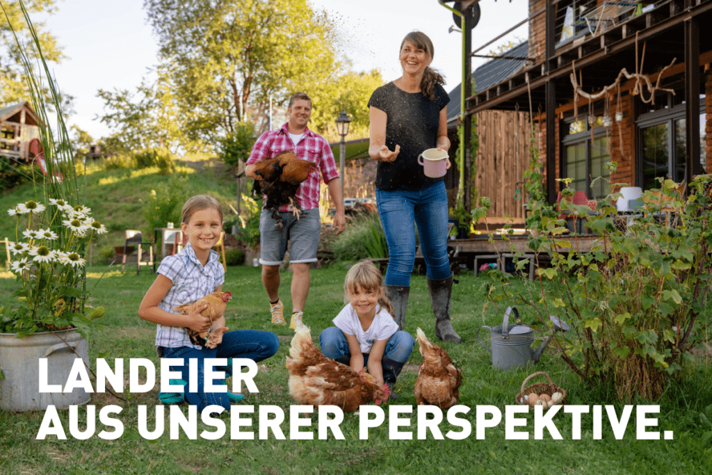 Schönes Landleben: Eine junge Familie füttert Hühner im Garten