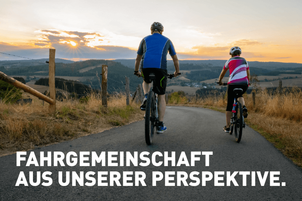 Fahrgemeinschaft: Zwei Radfahrer fahren bei Sonnenuntergang auf einer Straße mit Weitsicht